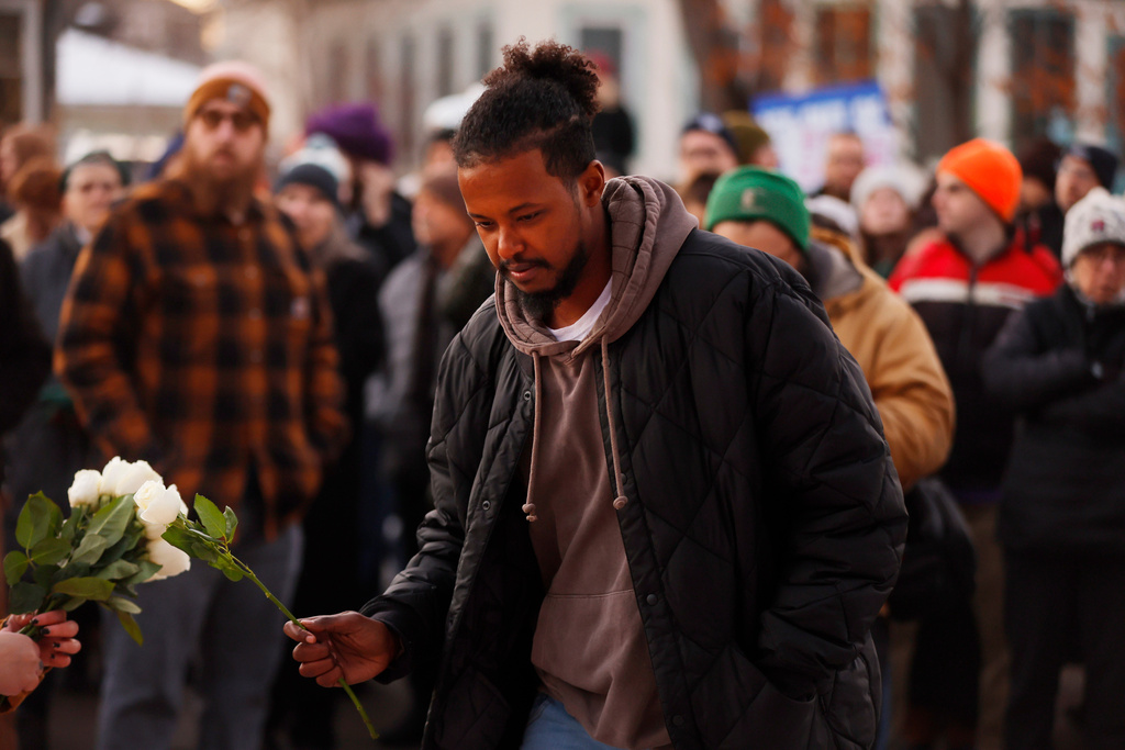 People gather for a vigil after an Immigration and Customs Enforcement officer shot and killed a woman earlier in the day, Wednesday, Jan. 7, 2026, in Minneapolis. (AP Photo/Bruce Kluckhohn)