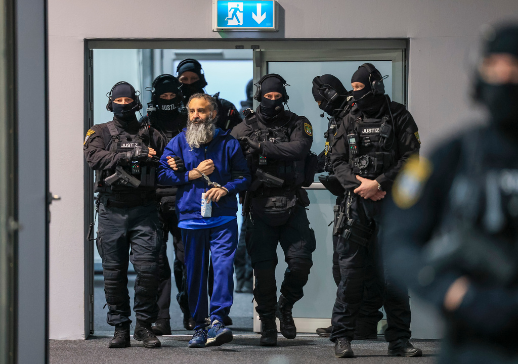 Judicial officers lead the defendant Taleb al-Abdulmohsen into the courtroom in the temporary court building of Magdeburg District Court for his trial in Magdeburg, Germany, Thursday, Nov. 20, 2025. (Jan Woitas/dpa via AP)