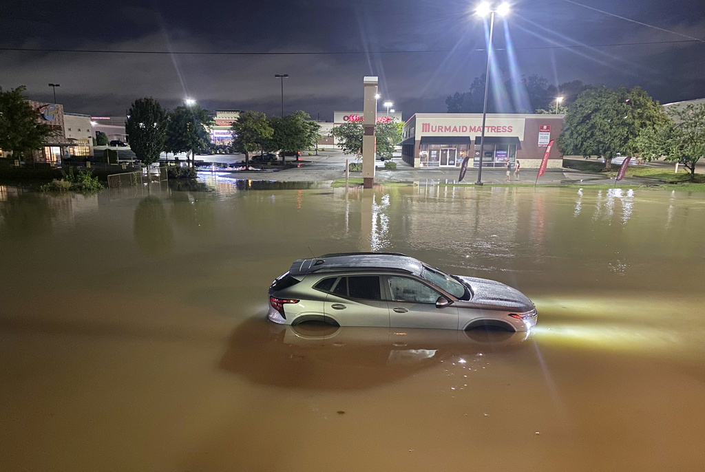A car is stranded in floodwater on Gunbarrel Road, in Chattanooga, Tenn., on Aug. 12, 2025. (Robin Rudd/Chattanooga Times Free Press via AP)