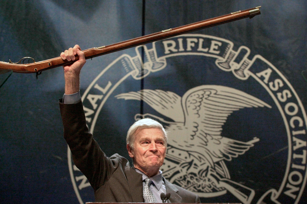 FILE - NRA president Charlton Heston holds up a musket as he tells the members attending the 129th Annual Meeting & Exhibit in Charlotte, N.C., that they can have his gun when they pry it, "from my cold dead hands," drawing a standing ovation, May 20, 2000. (AP Photo/Ric Feld, File)