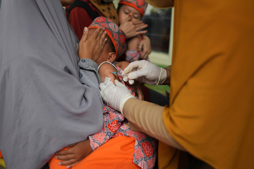 A health worker administers a measles shot during a vaccination campaign following an outbreak, at a kindergarten in Sumenep on Madura Island, Indonesia, Monday, Sept. 8, 2025. (AP Photo/Dita Alangkara)