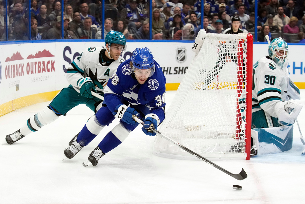 Tampa Bay Lightning left wing Brandon Hagel (38) beats San Jose Sharks center Alexander Wennberg (21) to the puck during the second period of an NHL hockey game Tuesday, Jan. 20, 2026, in Tampa, Fla. (AP Photo/Chris O'Meara)
