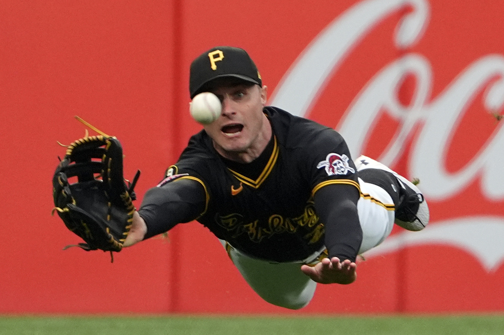 Pittsburgh Pirates left fielder Jake Mangum makes a diving attempt on a ball hit by Cincinnati Reds' Will Benson but is unable to make the diving catch in the eighth inning of a baseball game in Pittsburgh, Saturday, May 2, 2026. (AP Photo/Tom E. Puskar)