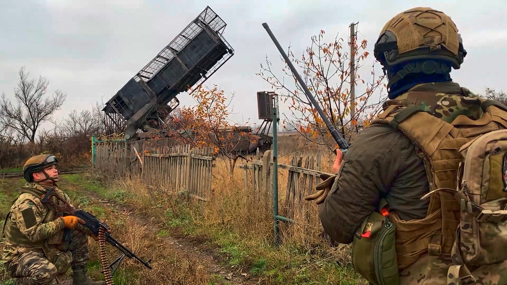 In this image made from video provided by Russian Defense Ministry Press Service on Friday, Nov. 7, 2025, Russian soldiers secure an area near a Russian "Grad" self-propelled 122 mm multiple rocket launcher prepared to fire towards Ukrainian positions on an undisclosed location in Ukraine. (Russian Defense Ministry Press Service via AP)