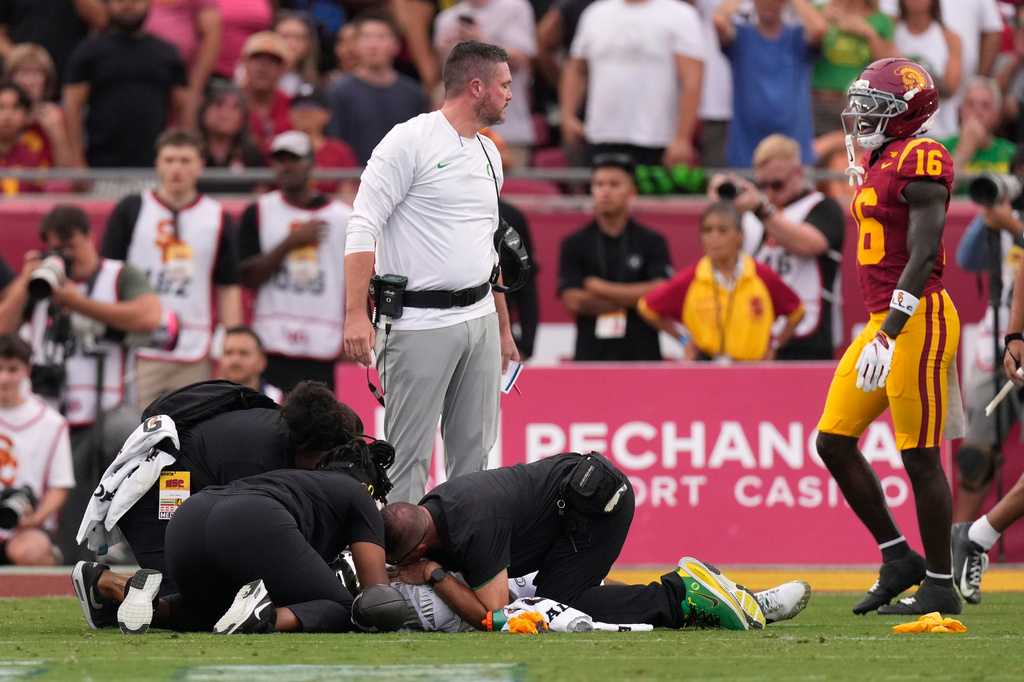 Oregon head coach Dan Lanning, upper left, looks at Southern California safety Prophet Brown, right, as Oregon quarterback Dante Moore is tended to following a hard tackle by Southern California linebacker Desman Stephens II during the first half of an NCAA college football game, Saturday, Sept. 26, 2026, in Los Angeles. (AP Photo/Mark J. Terrill)