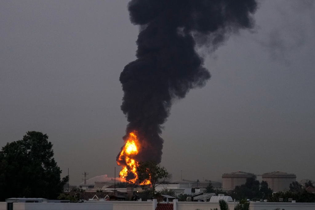 Fire and plumes of smoke rises after s drone struck a fuel tank forcing the temporary suspension of flights. near Dubai International Airport, in United Arab Emirates, early Monday, March 16, 2026. (AP Photo)