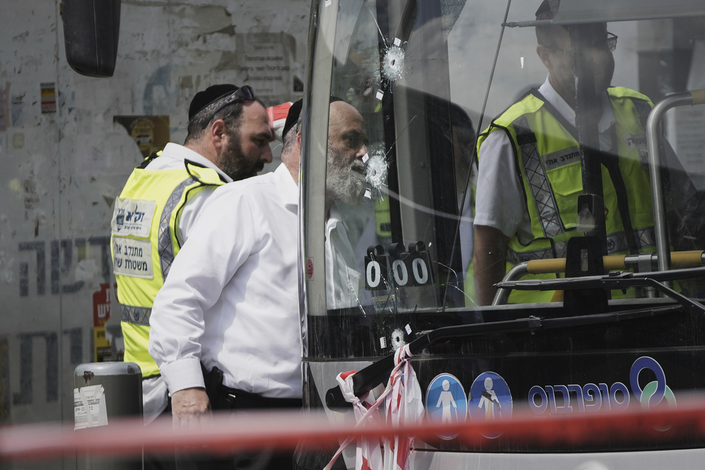 Israeli police and rescue teams inspect the scene of a shooting attack carried out by two Palestinian gunmen, in which several people were killed and others injured at a bus stop in Jerusalem, Monday, Sept. 8, 2025. (AP Photo/Mahmoud Illean)