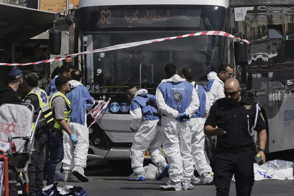 Israeli police and rescue teams inspect the scene of a shooting attack carried out by two Palestinian gunmen, in which several people were killed and others injured at a bus stop in Jerusalem, Monday, Sept. 8, 2025. (AP Photo/Mahmoud Illean)