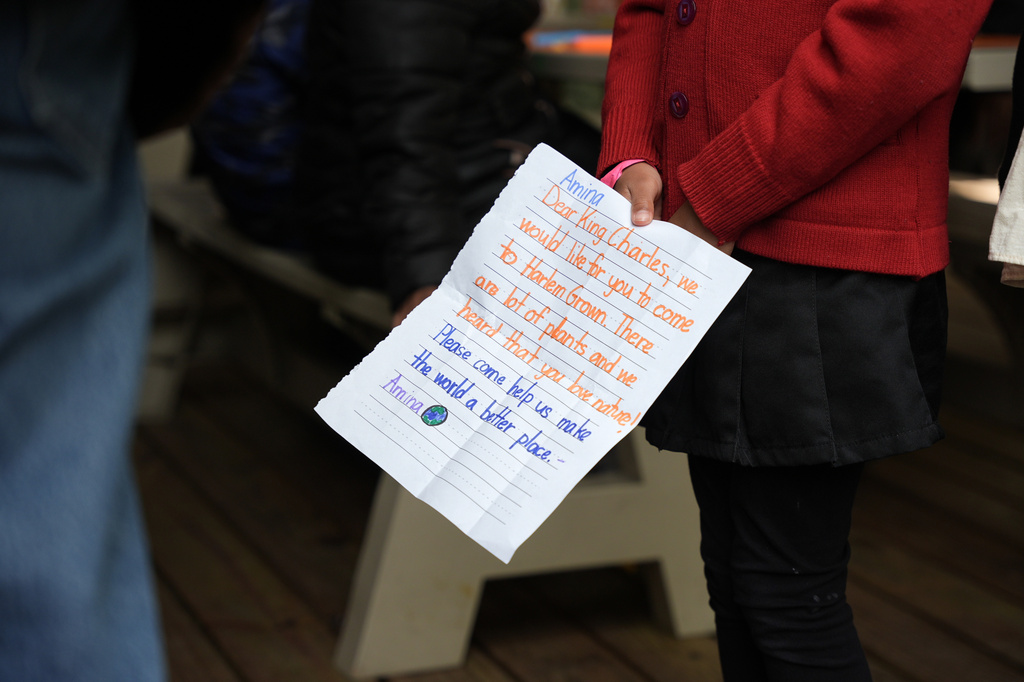 Britain's King Charles III receives a letter from a young attendee at a Harlem Grown event, Wednesday, April 29, 2026, in New York. (AP Photo/Angelina Katsanis, Pool)
