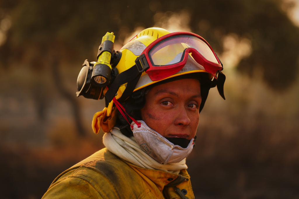 A firefighter pauses while battling a wildfire in San Martín de Valdeiglesias, west of Madrid, Spain, Sunday, July 26, 2026. (AP Photo/Manu Fernandez)