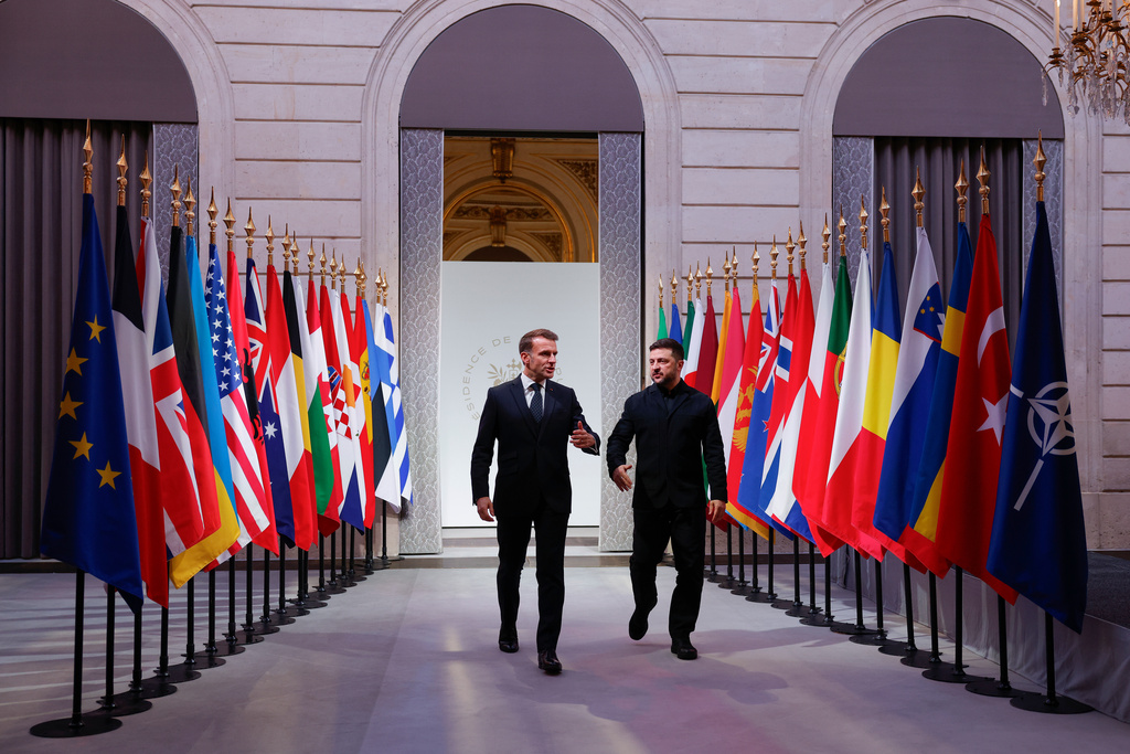 French President Emmanuel Macron, left, and Ukraine's President Volodymyr Zelenskyy arrive for a meeting of the Coalition of the Willing meeting at the Elysee Palace in Paris, France, Tuesday, Jan.6, 2026. (Yoan Valat, Pool photo via AP)