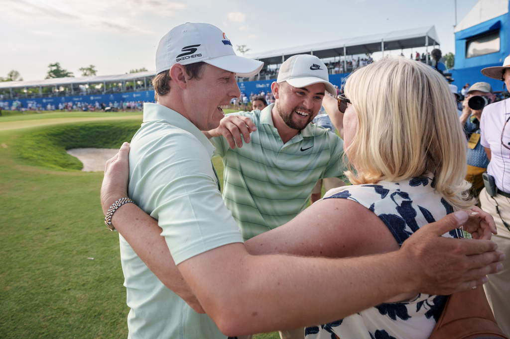 Matt Fitzpatrick, left, of England, hugs his mother Susan Fitzpatrick, right, after he and brother Alex Fitzpatrick, center, won the PGA Zurich Classic of New Orleans golf tournament, Sunday, April 26, 2026, in Avondale, La. (AP Photo/Matthew Hinton)