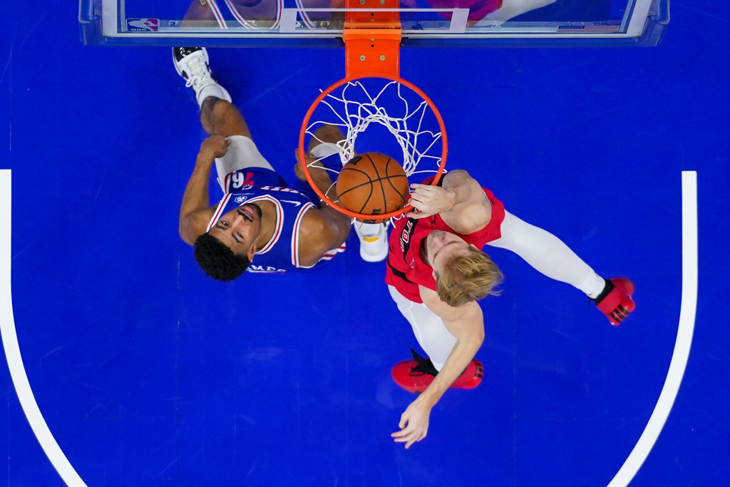 Toronto Raptors' Gradey Dick, right, dunks the ball with Philadelphia 76ers' Quentin Grimes, left, defending during the first half of an NBA basketball game, Wednesday, Nov. 19, 2025, in Philadelphia. (AP Photo/Chris Szagola)