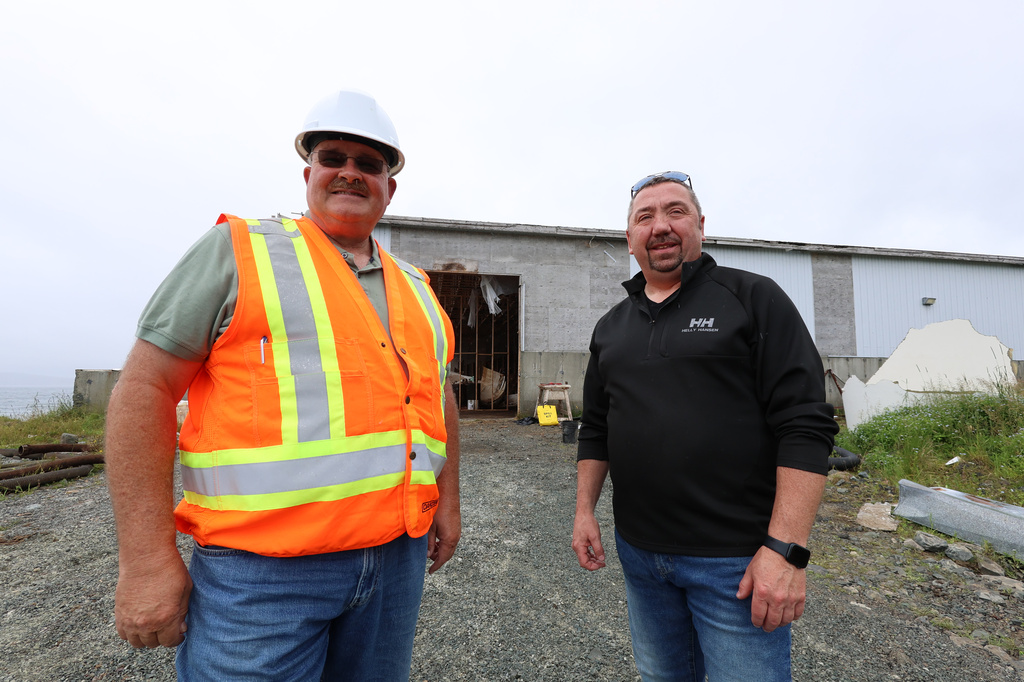 Glenn Sharp, left, owner of Sharp Management, stands next to Steve Ryan, mayor of St. Mary's, N.L., in front of an abandoned fish sauce factory in the town on Tuesday, July 28, 2026. (Elling Lien/The Canadian Press via AP)