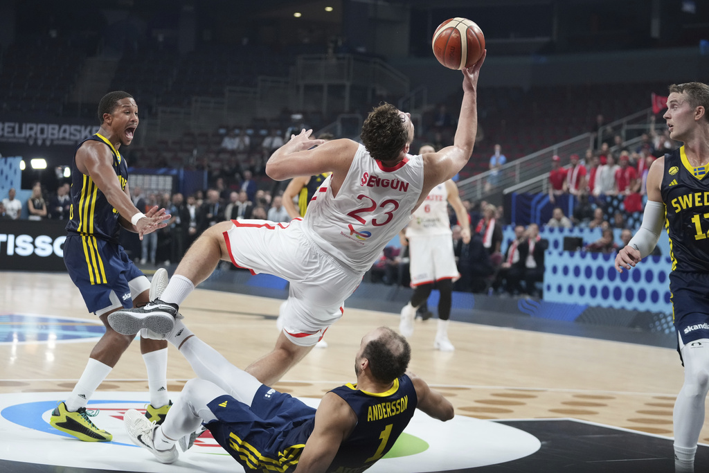 Sweden's Denzel Andersson, bottom, falls after colliding with Turkey's Alperen Sengun, centre, during the Eurobasket, European Basketball Championship round of 16 match between Turkey and Sweden at the Riga Arena in Riga, Latvia, Saturday, Sept. 6, 2025. (AP Photo/Sergei Grits)