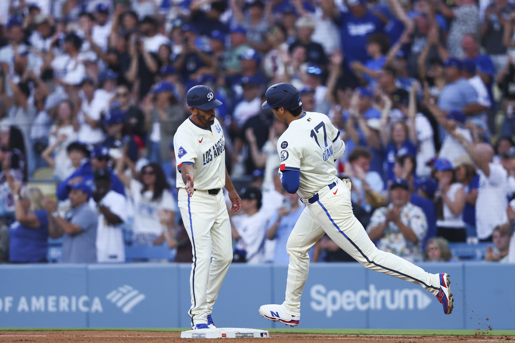 Los Angeles Dodgers' Shohei Ohtani (17) celebrates with first base coach Chris Woodward, left, after hitting a home run during the fifth inning of a baseball game against the Toronto Blue Jays, Saturday, Aug. 9, 2025, in Los Angeles. (AP Photo/Jessie Alcheh)