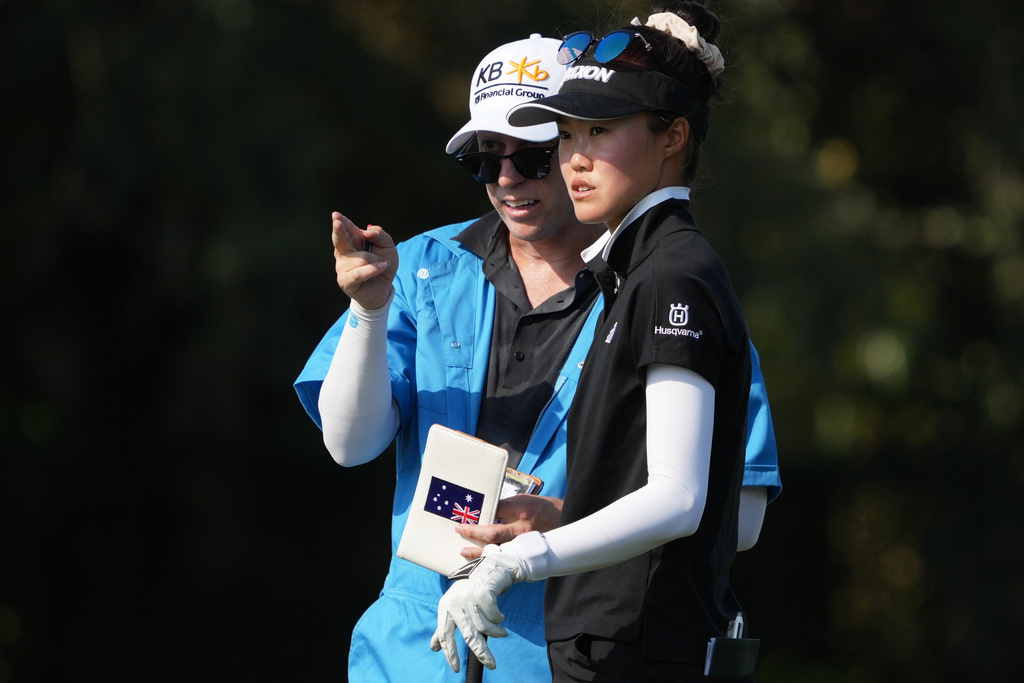 Grace Kim of Australia and her caddie look down the 17th fairway during the first round of the LPGA Tour Championship golf tournament, Thursday, Nov. 20, 2025, in Naples, Fla. (AP Photo/Marta Lavandier)