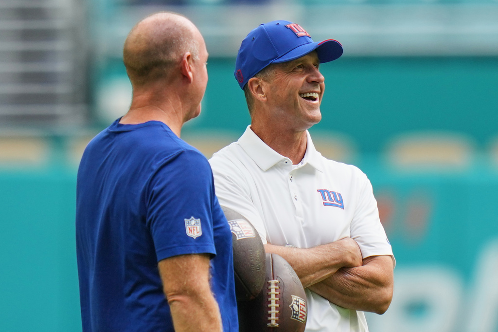 New York Giants head coach John Harbaugh, right, talks on the field before a preseason NFL football game against the Miami Dolphins, Saturday, Aug. 22, 2026, in Miami Gardens, Fla. (AP Photo/Lynne Sladky)