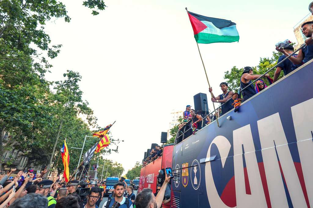 El astro del Barcelona Lamine Yamal sostiene una bandera palestina al celebrar la consagración del equipo como campeones de la Liga de España, el lunes 11 de mayo de 2026, en Barcelona. (AP Foto)