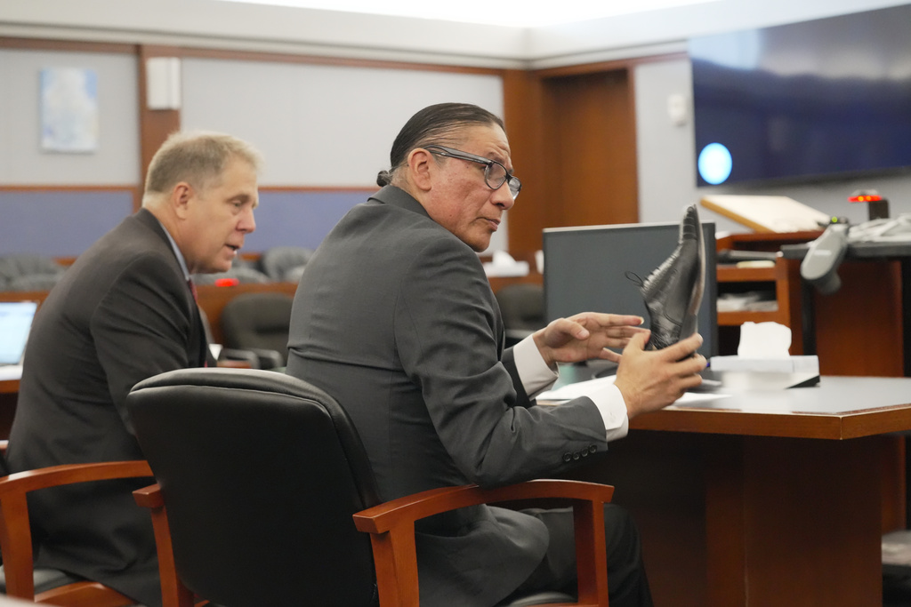 Nathan Chasing Horse, right, sitting next to attorney Craig Mueller, holds a shoe as he appears for his trial on charges of sexually abusing Indigenous women and girls Tuesday, Jan. 13, 2026, in Las Vegas. (AP Photo/Ty ONeil)