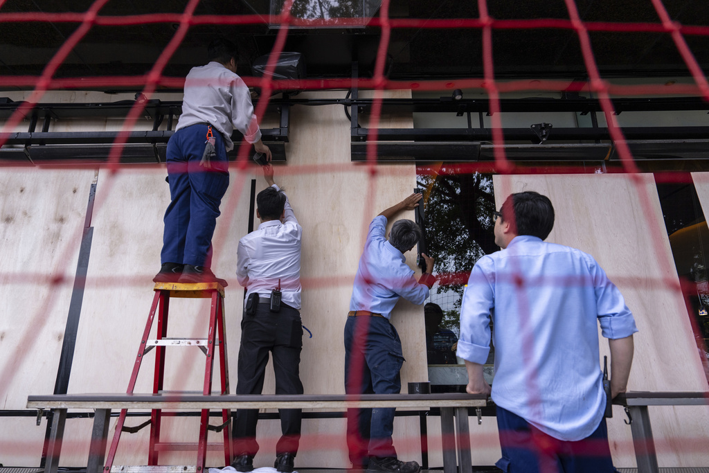 Workers install protective barriers at a restaurant ahead of the super typhoon Ragasa approaching Hong Kong, Tuesday, Sept. 23, 2025. (AP Photo/Chan Long Hei)
