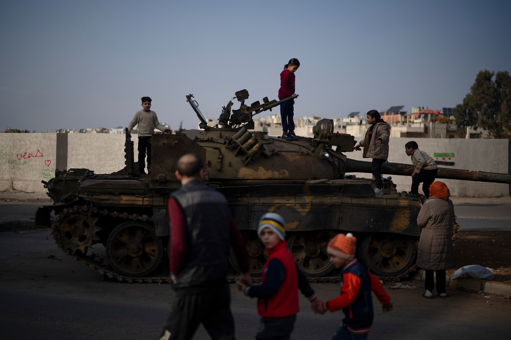 FILE - Children on the top of an ousted Syrian government forces tank that was left on a street in an Alawite neighbourhood, in Homs, Syria, Dec. 26, 2024. (AP Photo/Leo Correa, File)