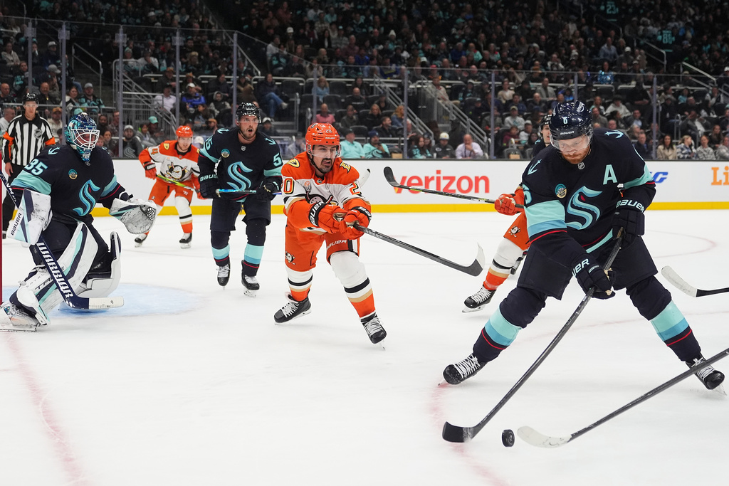 Seattle Kraken defenseman Adam Larsson, far right, moves the puck away from Anaheim Ducks left wing Chris Kreider, second from right, during the second period of an NHL hockey game Thursday, Oct. 9, 2025, in Seattle. (AP Photo/Lindsey Wasson)