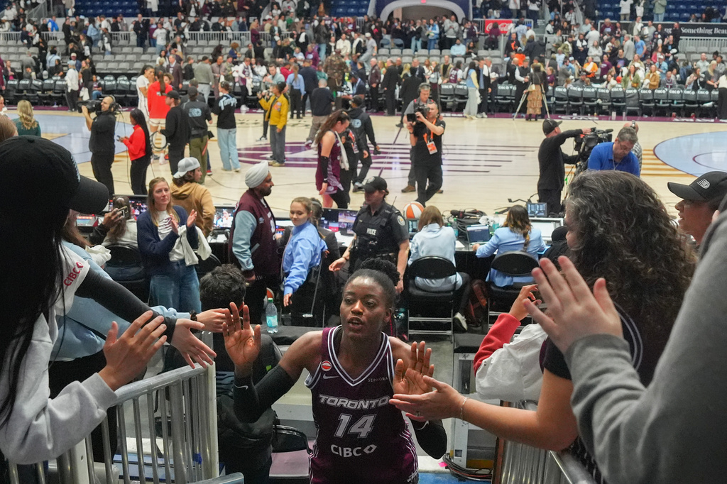 Toronto Tempo's Temi Fagbenle (14) high-fives fans as she comes off the court after her team's first WNBA basketball game, aganst the Washington Mystics, in Toronto, Friday, May 8, 2026. (Chris Young/The Canadian Press via AP)
