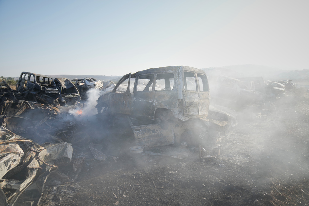 Smoke rises from scorched cars in a scrapyard that was set ablaze the night before by who local residents alleged were Israeli settlers in the town of Huwara near the West Bank city of Nablus, Friday, Nov. 21, 2025. (AP Photo/Nasser Nasser)