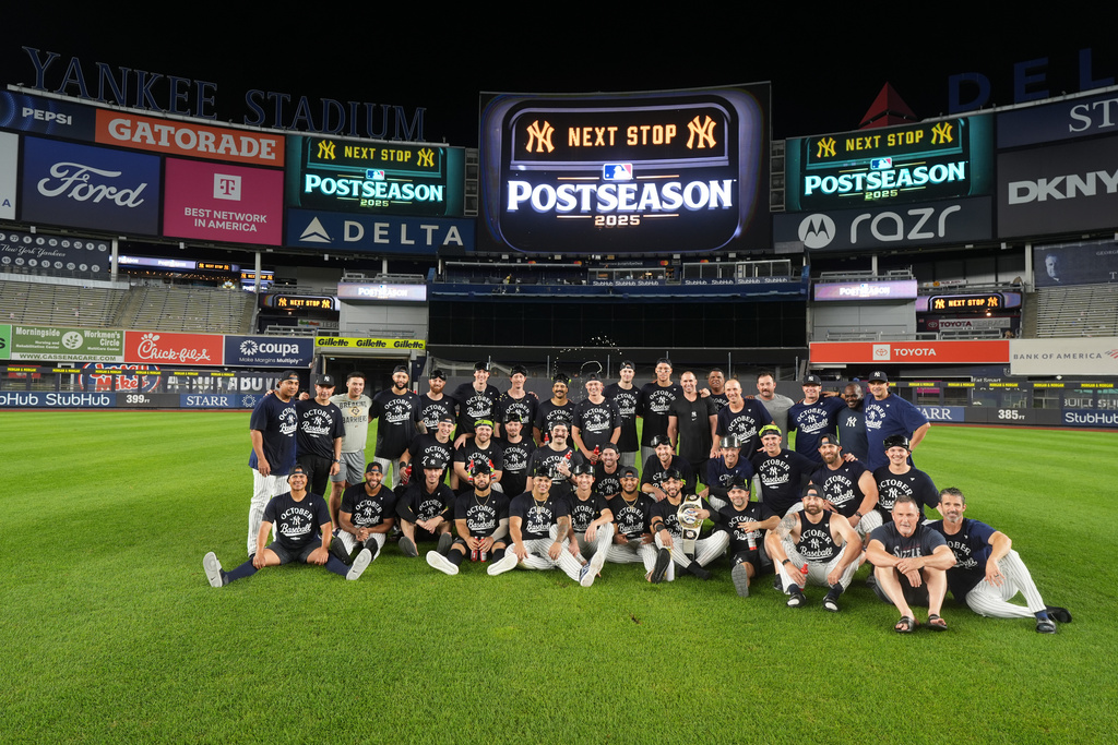 The New York Yankees pose for photographs after they clinched playoff berth in a baseball game against the Chicago White Sox Tuesday, Sept. 23, 2025, in New York. (AP Photo/Frank Franklin II)
