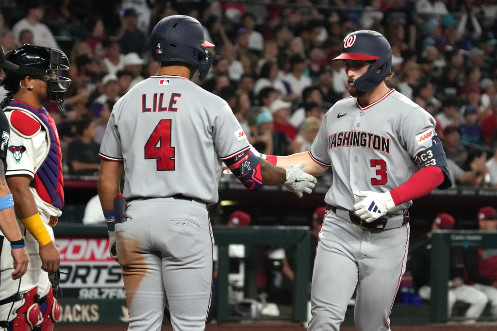 Washington Nationals' Dylan Crews celebrates with Daylen Lile (4) after hitting a solo home run against the Arizona Diamondbacks in the seventh inning of a baseball game, Saturday, June 6, 2026, in Phoenix. (AP Photo/Rick Scuteri)