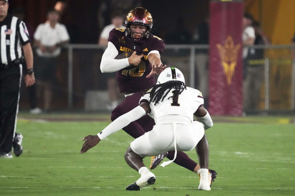 Arizona State quarterback Sam Leavitt stiff arms Texas State safety Bobby Crosby (1) in the first half of an NCAA college football game, Saturday, Sept. 13, 2025, in Tempe, Ariz. (AP Photo/Rick Scuteri)