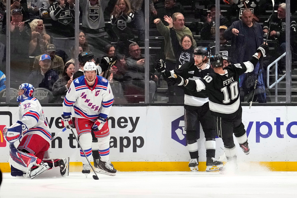 Los Angeles Kings right wing Adrian Kempe, second from right, celebrates his goal with right wing Corey Perry, right, as New York Rangers goaltender Jonathan Quick, left, and center J.T. Miller stand by during the first period of an NHL hockey game Tuesday, Jan. 20, 2026, in Los Angeles. (AP Photo/Mark J. Terrill)