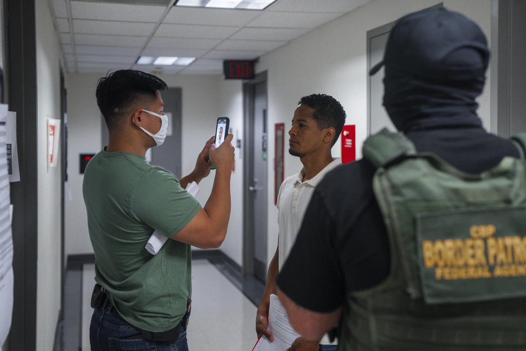 An Immigration and Customs Enforcement (ICE) agent uses facial recognition software to confirm an asylum seeker's identity prior to an immigration hearing inside, Wednesday, July 30, 2025, in New York. (AP Photo/Olga Fedorova)