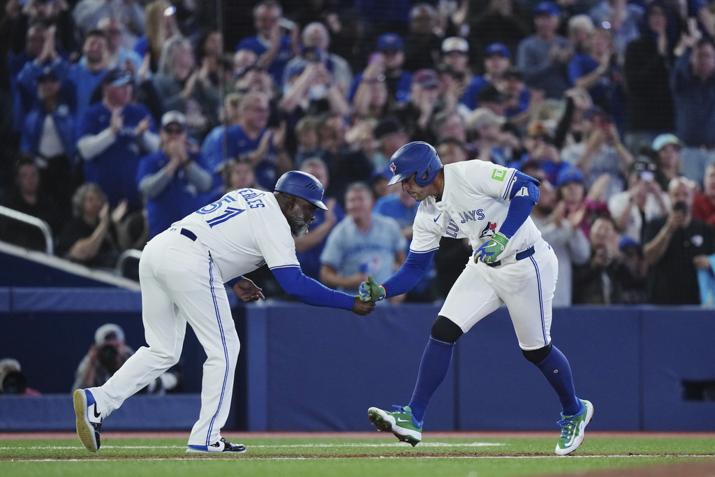 Toronto Blue Jays' George Springer (right) celebrates his solo home run against the Houston Astros with third base coach Carlos Febles (51) during sixth inning MLB baseball action in Toronto on Tuesday, Sept. 9, 2025. (Nathan Denette/The Canadian Press via AP)
