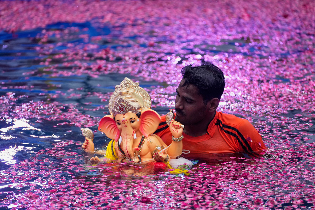 An Indian volunteer carries an idol of elephant-headed Hindu god Ganesha to immerse in an artificial pond, in Mumbai, India, Aug. 28, 2025. (AP Photo/Rajanish Kakade, File)