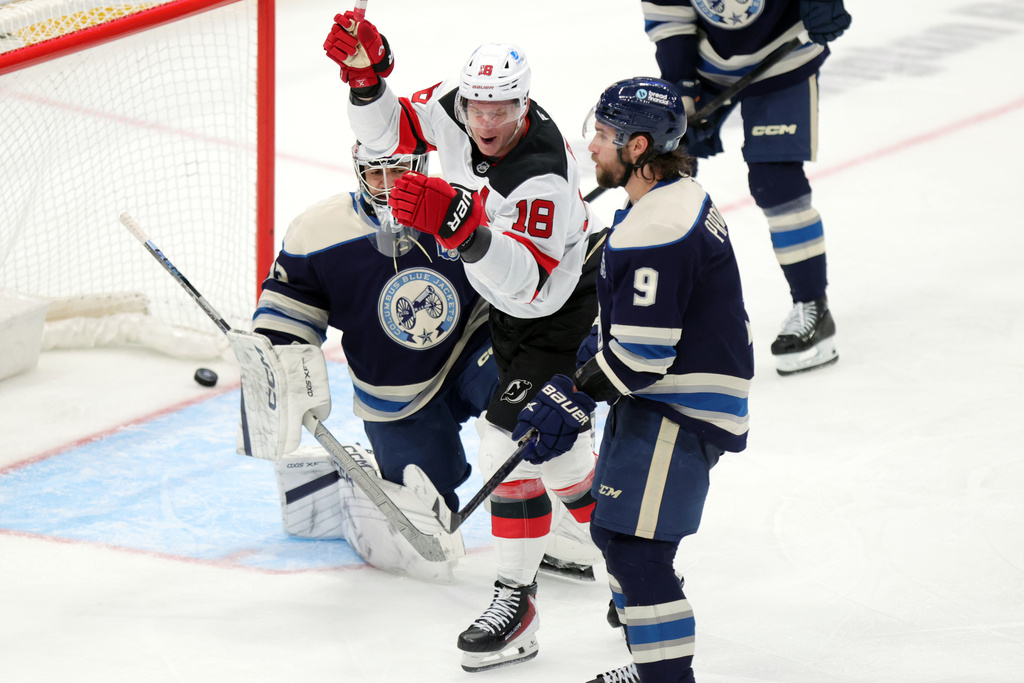 New Jersey Devils forward Ondrej Palat, center, celebrates between Columbus Blue Jackets goalie Jet Greaves, left, and defenseman Ivan Provorov after teammate defenseman Luke Hughes' goal during the third period of an NHL hockey game in Columbus, Ohio, Wednesday, Dec. 31, 2025. (AP Photo/Paul Vernon)