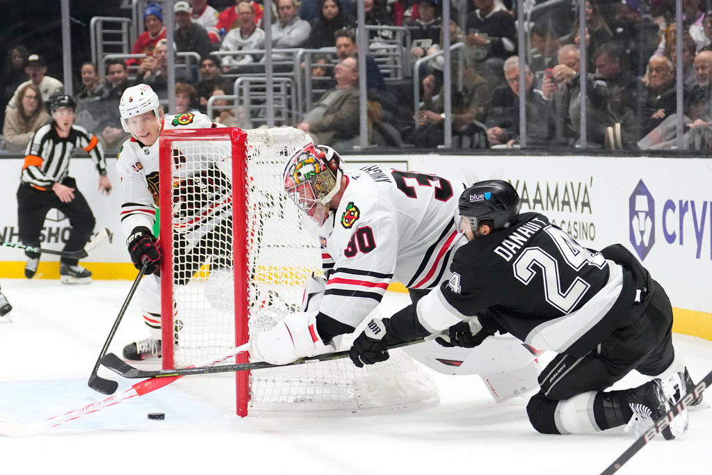 Los Angeles Kings center Phillip Danault, right, tries to get a shot in as Chicago Blackhawks defenseman Connor Murphy, left, and goaltender Spencer Knight defend during the second period of an NHL hockey game Thursday, Dec. 4, 2025, in Los Angeles. (AP Photo/Mark J. Terrill)