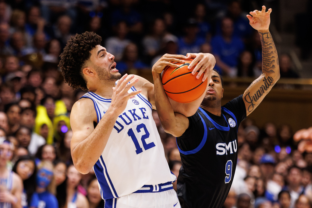 Duke's Cameron Boozer (12) and SMU's B.J. Davis-Ray (9) battle for the ball during the second half of an NCAA college basketball game in Durham, N.C., Saturday, Jan. 10, 2026. (AP Photo/Ben McKeown)