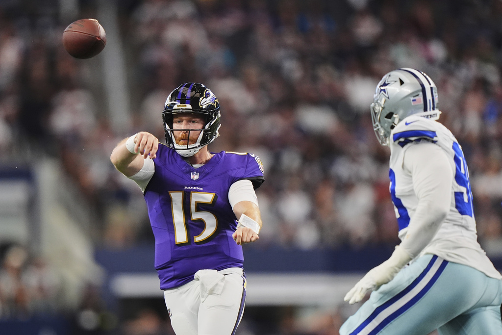 Baltimore Ravens quarterback Cooper Rush (15) throws a pass under pressure from the Dallas Cowboys defense in the first half of a preseason NFL football game Saturday, Aug. 16, 2025, in Arlington, Texas. (AP Photo/LM Otero)