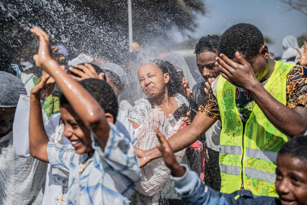 Holy water is sprayed on Ethiopian Orthodox worshippers, during the celebration of the Ethiopian Epiphany on lake Dembel, in Batu, Ethiopia, Monday, Jan. 19, 2026. (AP Photo/Amanuel Sileshi)