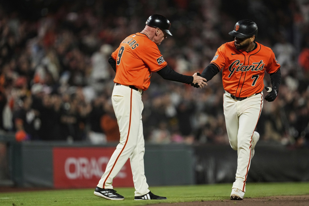 San Francisco Giants' Dominic Smith (7) celebrates with third base coach Matt Williams after hitting a two-run home run during the fourth inning of a baseball game against the Baltimore Orioles, Friday, Aug. 29, 2025, in San Francisco. (AP Photo/Godofredo A. Vásquez)
