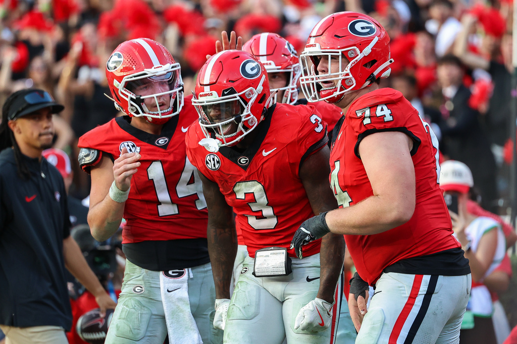Georgia running back Nate Frazier (3) reacts with quarterback Gunner Stockton (14) and offensive lineman Drew Bobo (74) after scoring a touchdown during the second half of an NCAA college football game against Mississippi, Saturday, Oct. 18, 2025, in Athens, Ga. (AP Photo/Colin Hubbard)