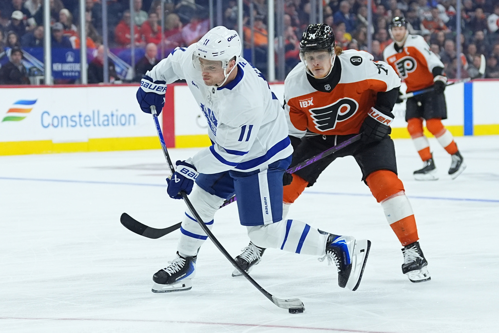 Toronto Maple Leafs' Max Domi (11) takes a shot past Philadelphia Flyers' Owen Tippett during the third period of an NHL hockey game, Thursday, Jan. 8, 2026, in Philadelphia. (AP Photo/Matt Rourke)