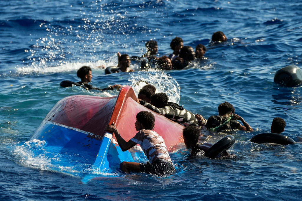 FILE-- Migrants from Syria and Libya in a wooden boat call for help as they are assisted by Spanish NGO Open Arms during a rescue operation inside Malta's SAR zone south of the Italian island of Lampedusa in the Mediterranean sea, Thursday, Aug. 11, 2022. (AP Photo/Francisco Seco)