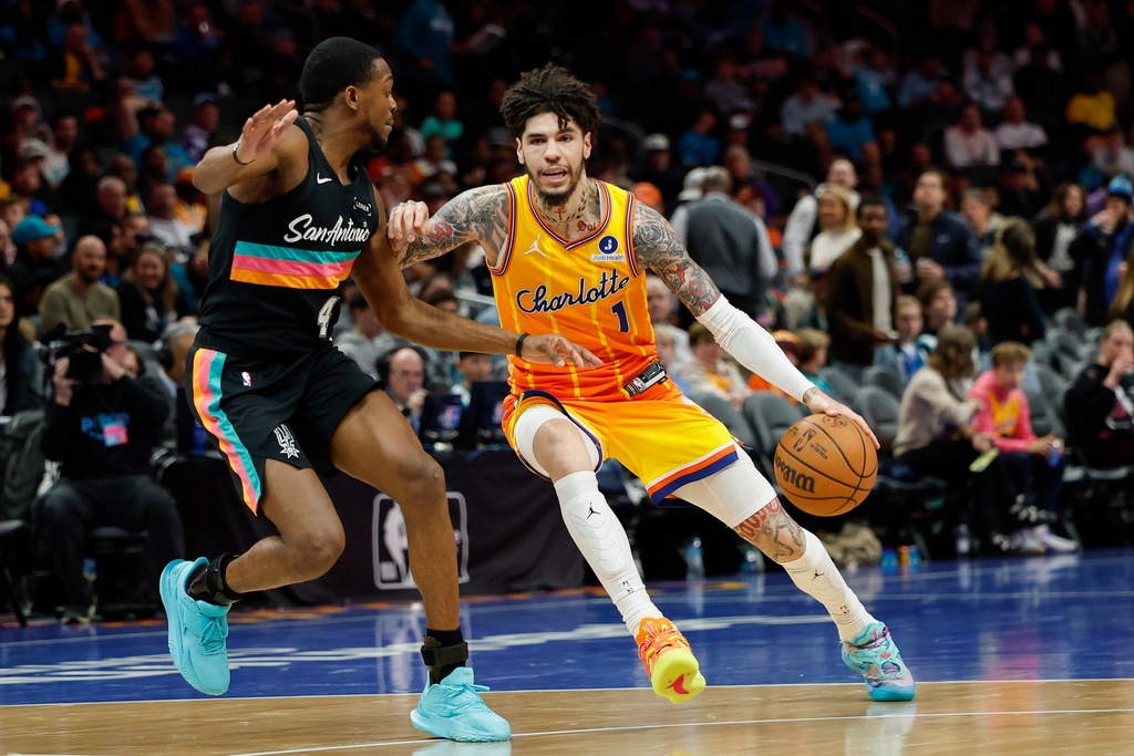 Charlotte Hornets guard LaMelo Ball (1) drives against San Antonio Spurs guard De'aaron Fox during the second half of an NBA basketball game in Charlotte, N.C., Saturday, Jan. 31, 2026. (AP Photo/Nell Redmond)