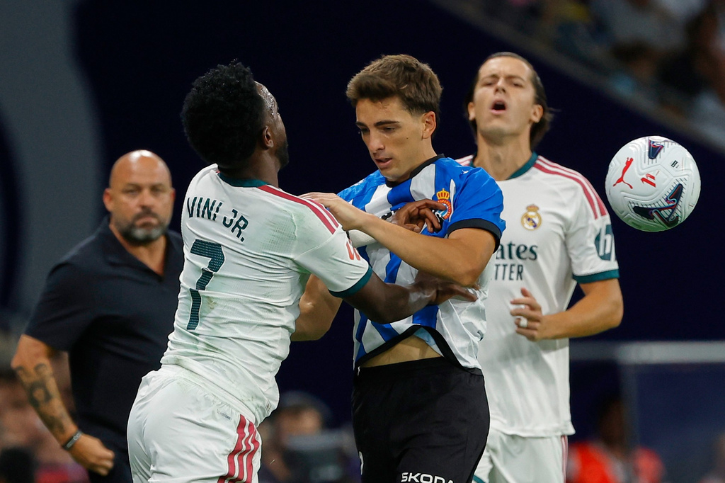 Real Madrid's Vinicius Junior, left, vies for the ball with Espanyol's Carlos Romero during a Spanish La Liga soccer match between Espanyol and Real Madrid in Barcelona, Spain, Saturday, Aug. 22, 2026. (AP Photo/Joan Monfort)