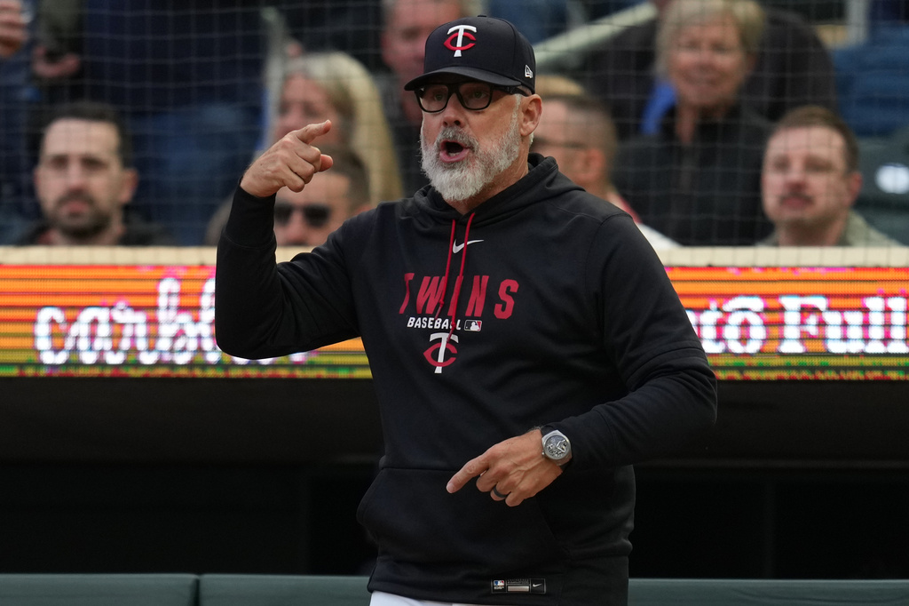 Minnesota Twins manager Derek Shelton signals for a replay review during the first inning of a baseball game against the Boston Red Sox Tuesday, April 14, 2026, in Minneapolis. (AP Photo/Abbie Parr)