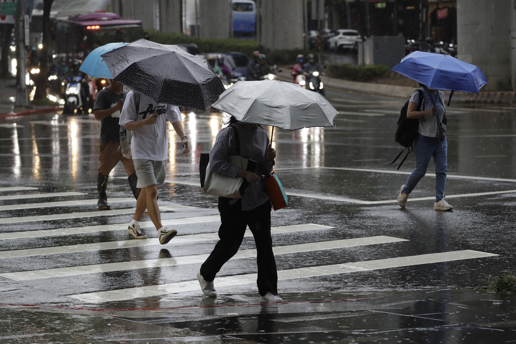 People walk in the rain caused by typhoon Ragasa in Taipei, Taiwan Tuesday, Sept. 23, 2025. (AP Photo/Chiang Ying-ying)