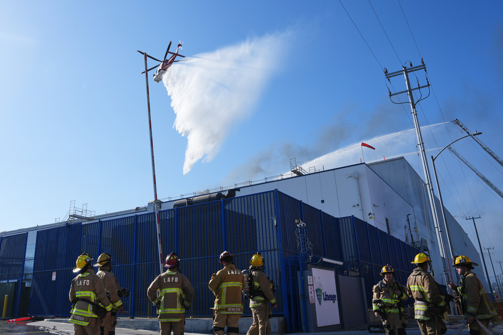 Water is dropped by helicopter at a warehouse fire in the Boyle Heights section of Los Angeles on Wednesday, June 17, 2026. (AP Photo/Jae C. Hong)